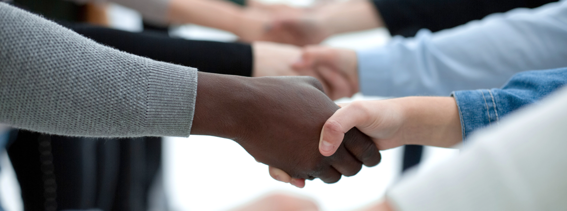 A close-up of a diverse group of people shaking hands